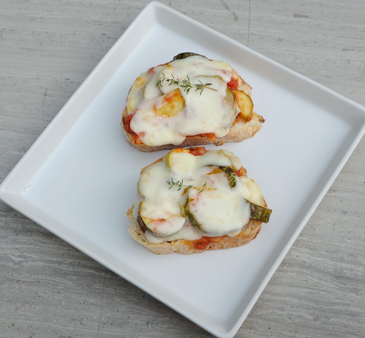 Zucchini Crostini with Melted Cheese ,Thyme Sprigs Garnish